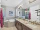 Elegant bathroom featuring a soaking tub, double vanity, and granite countertop at 10325 Longshore Rd # 17, Placida, FL 33946