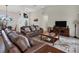 Spacious living room featuring brown leather sofas, a large TV, and a coffee table at 10549 Washington Rd, Port Charlotte, FL 33981