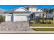 Exterior of a light blue house with white accents, double garage, and landscaped yard at 12450 Vieste Ct, Venice, FL 34293