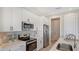 Clean and bright kitchen with white cabinets, stainless steel appliances and quartz countertops at 14304 Amestoy Ave, Port Charlotte, FL 33981