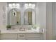 Bathroom with double vanity, large mirrors, and stylish blue patterned wallpaper at 14304 Amestoy Ave, Port Charlotte, FL 33981
