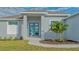 Contemporary home's front entrance with a teal door at 14304 Amestoy Ave, Port Charlotte, FL 33981