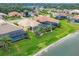 Aerial view of community, showcasing houses with pools near the lake at 1985 Coconut Palm Cir, North Port, FL 34288