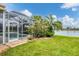 Landscaped backyard with pool, screened enclosure, and lake view at 1985 Coconut Palm Cir, North Port, FL 34288