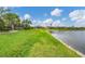 Spacious backyard with lake view, lush landscaping, and a relaxing atmosphere at 1985 Coconut Palm Cir, North Port, FL 34288