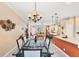 Open dining room with glass table and view into living area at 1985 Coconut Palm Cir, North Port, FL 34288