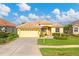 Single-story home with a yellow exterior and a two-car garage at 1985 Coconut Palm Cir, North Port, FL 34288