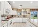 Kitchen with white cabinets, a large window, and access to backyard at 1985 Coconut Palm Cir, North Port, FL 34288
