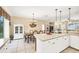 Kitchen with white cabinets, island, and dining area with chandelier at 1985 Coconut Palm Cir, North Port, FL 34288