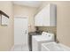 Bright laundry room with washer, dryer, and storage cabinets at 1985 Coconut Palm Cir, North Port, FL 34288
