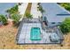 Aerial view of a screened-in pool and spa surrounded by lush landscaping on a sunny day at 268 Rotonda W Blvd # 1B, Rotonda West, FL 33947