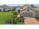 Single-story home with tile roof, two-car garage, and landscaped yard at 27467 Janzen Ct, Englewood, FL 34223