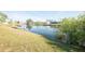 Backyard with dock and chairs on the canal that is surrounded by lush greenery at 42 Caroll Cir, Englewood, FL 34223