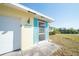 Front view of the house with teal shutters and a pond view at 42 Caroll Cir, Englewood, FL 34223