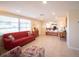 Open living room with red couch, tiled floors, and a view to the kitchen at 42 Caroll Cir, Englewood, FL 34223