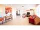 Living room features tiled floors, red sofa, and a view into the kitchen at 42 Caroll Cir, Englewood, FL 34223