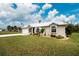 Charming single-story home with white metal roof, landscaping, and driveway at 6 Tournament Rd, Rotonda West, FL 33947