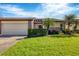 Front view of charming villa with two-car garage, lush landscaping, and attractive curb appeal at 618 Deerwood Ave, Englewood, FL 34223