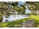 Serene lake view with bench under oak tree at 618 Deerwood Ave, Englewood, FL 34223