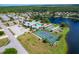 Aerial view of community with tennis court and lake at 618 Deerwood Ave, Englewood, FL 34223