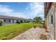Back patio with brick pavers and access to grassy backyard at 618 Deerwood Ave, Englewood, FL 34223