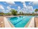 Inviting community pool with lounge chairs and brick deck at 618 Deerwood Ave, Englewood, FL 34223