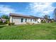 Back of house showing landscaping and grassy backyard at 618 Deerwood Ave, Englewood, FL 34223