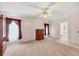 Main bedroom with a ceiling fan, carpet flooring, and access to the bathroom at 749 Riverview Cir, North Port, FL 34287