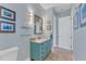 Small bathroom with teal vanity and a walk-in shower at 8025 Weyers Ct, Englewood, FL 34224