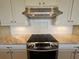 Stainless steel cooktop with modern ventilation hood at 8025 Weyers Ct, Englewood, FL 34224