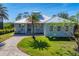 Single-story home with metal roof, paver driveway, and tropical landscaping at 8025 Weyers Ct, Englewood, FL 34224