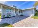 Single-story home with metal roof, paver driveway, and lush landscaping at 8025 Weyers Ct, Englewood, FL 34224