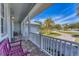 Relaxing front porch with white railings and two purple benches overlooking the yard at 8025 Weyers Ct, Englewood, FL 34224