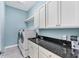 Laundry room with white cabinets, granite countertops, and LG washer/dryer at 8025 Weyers Ct, Englewood, FL 34224