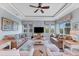 Bright living room with comfy seating, large windows, and a ceiling fan at 8025 Weyers Ct, Englewood, FL 34224