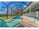 Relaxing pool and patio area with screened enclosure, lounge chairs, and lush landscaping at 8025 Weyers Ct, Englewood, FL 34224