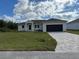 Single story home with a dark garage door and paved driveway at 9992 Antler St, Port Charlotte, FL 33981
