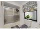 Simple bathroom with shower/tub combo and a window for natural light at 10127 Peach Ave, Englewood, FL 34224