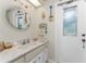 Coastal-themed bathroom with vanity, sink, and access to backyard at 10127 Peach Ave, Englewood, FL 34224