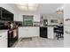 Bright kitchen features white cabinets, a tile floor, and stainless steel appliances at 10127 Peach Ave, Englewood, FL 34224