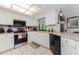 Modern kitchen with white cabinets, stainless steel appliances, and tile floor at 10127 Peach Ave, Englewood, FL 34224