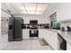 Bright kitchen features white cabinets, tile floor, and stainless steel appliances at 10127 Peach Ave, Englewood, FL 34224
