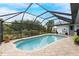 Enclosed kidney-shaped swimming pool with brick pavers at 10127 Peach Ave, Englewood, FL 34224