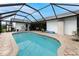 Enclosed kidney-shaped swimming pool with brick pavers at 10127 Peach Ave, Englewood, FL 34224