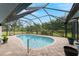 Enclosed kidney-shaped swimming pool with brick pavers at 10127 Peach Ave, Englewood, FL 34224