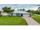 Single story home with a large yard and driveway at 10413 Grail Ave, Englewood, FL 34224