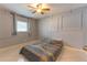 Bedroom with tiled floors, ceiling fan, and a bed with multicolored bedding at 10413 Grail Ave, Englewood, FL 34224