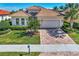 Single-story home with tile roof, landscaping, and a paved driveway at 12960 N Marsh Dr, Port Charlotte, FL 33953