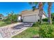 Attached garage with light beige door and landscaping at 12960 N Marsh Dr, Port Charlotte, FL 33953