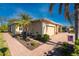Exterior view of a tan house with a paved walkway, palm trees, and American flag at 13488 Abercrombie Dr, Englewood, FL 34223